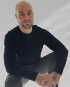 Portrait of JR, transformational coach, seated calmly in a minimalist setting